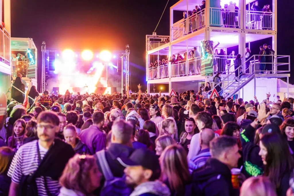 Koncert v zóne IQOS Curious City na Pohode – dav pred pódiom a ľudia na balkónoch trojposchodovej kontajnerovej stavby