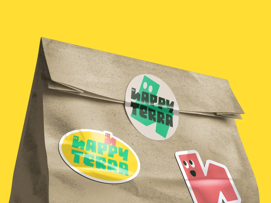 Farebné nálepky s logom, maskotom a názvom Happy Terra nalepené na papierovej obálke